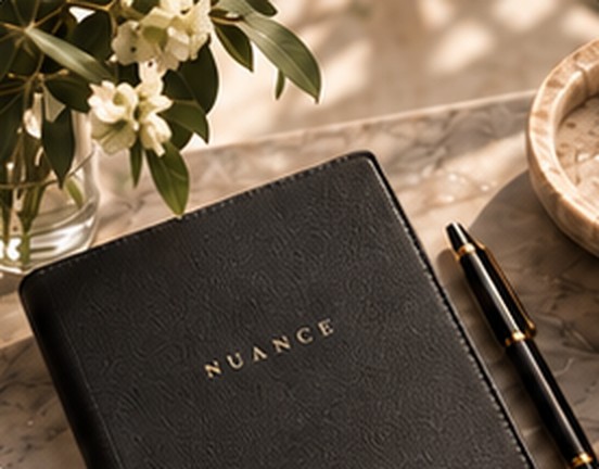A notebook and pen beside flowers